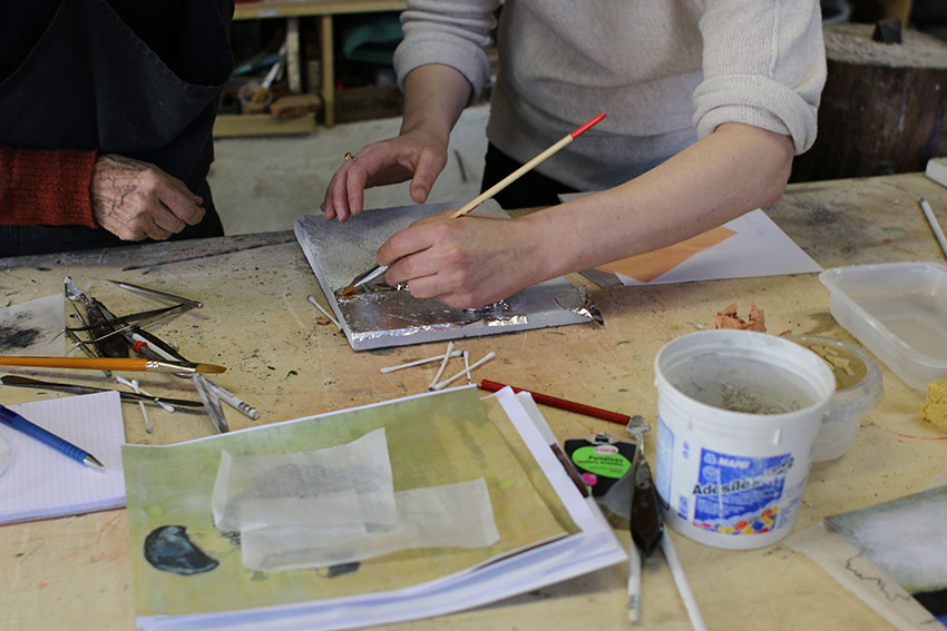 Pose par Matylda Tracewska de la feuille d'aluminium au pinceau sur le mortier, à l'atelier Mosaicozette